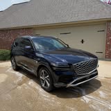 Front of a dark Genesis SUV in a driveway