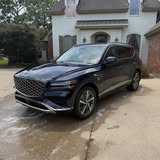Dark Genesis SUV parked outside a home